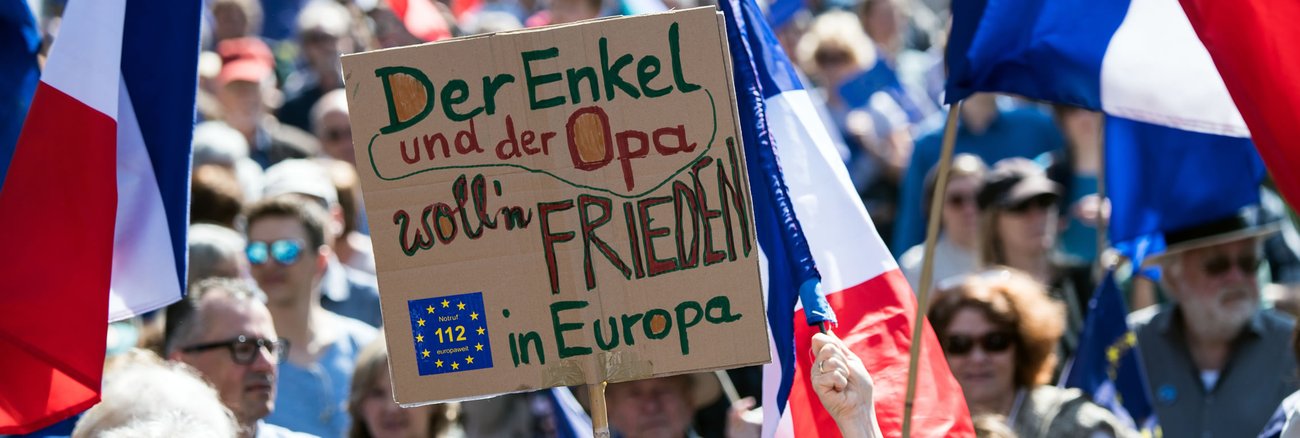 Bei einer Puls of Europe-Kundgebung in Frankfurt am Main hält ein Teilnehmer ein Schild mit der Aufschrift »Der Enkel und der Opa wollen Frieden in Europa« © Andreas Arnold/dpa