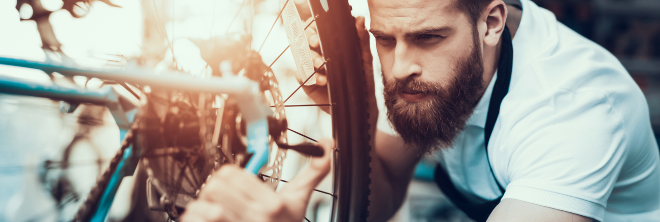 Ein Mechaniker repariert ein Fahrrad © iStock/vadimguzhva