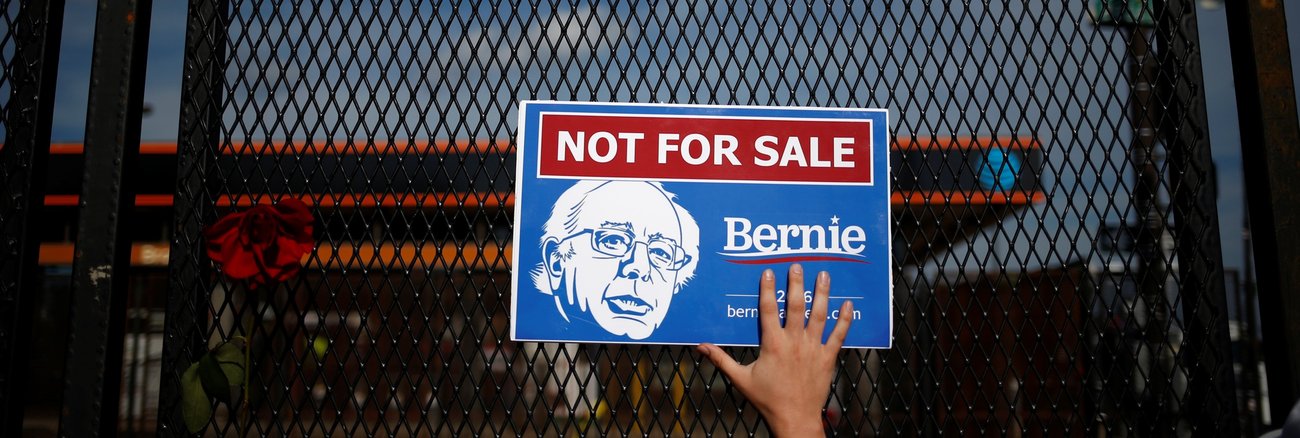 Eine Frau hält ein Schild mit der Aufschrift »Not for sale, Bernie« an einen Zaun © REUTERS/Adrees Latif