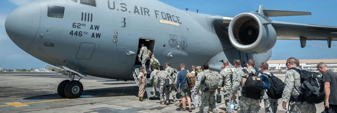 US-Soldaten in Zivil und Uniformen besteigen mit Gepäck ein Flugzeug mit der Aufschrift US Air Force © picture alliance/ZUMAPRESS.com/Maj. Dale Greer