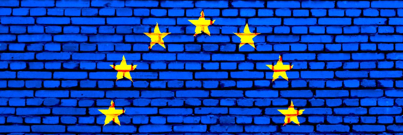 Blau angestrichene Backsteinwand mit EU-Sternen © iStockphoto.com/sigurcamp