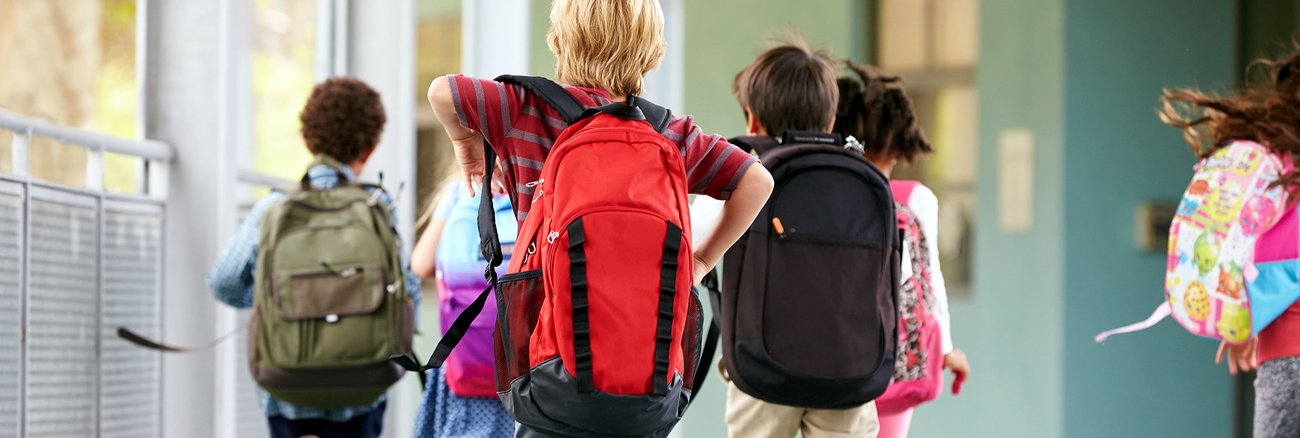 Schulkinder mit Rucksäcken rennen © iStockphoto.com/monkeybusinessimages