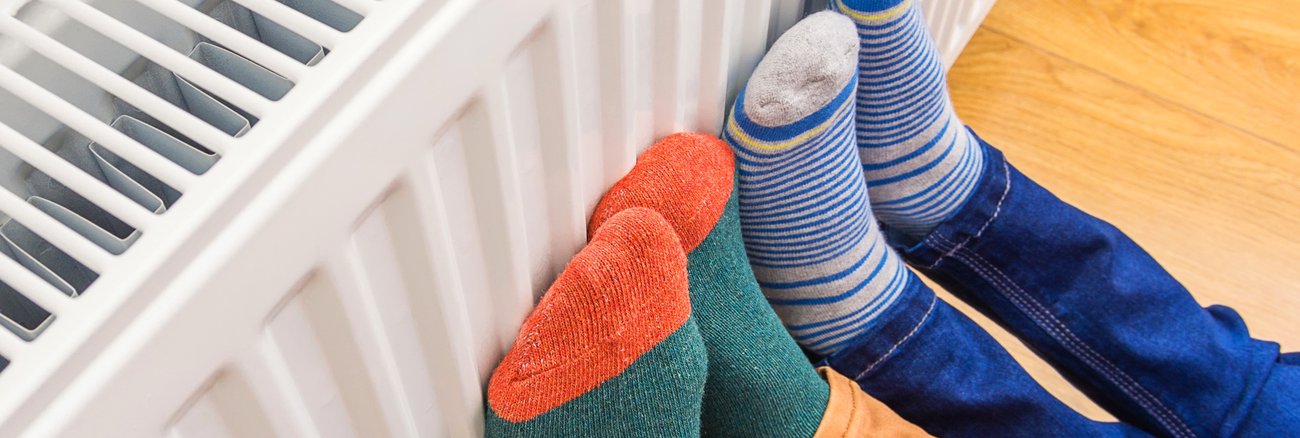 Zwei Paar Füße mit Wollsocken an einem Heizkörper © iStock/Evgen_Prozhyrko Zwei Paar Füße mit Wollsocken an einem Heizkörper © iStock/Evgen_Prozhyrko