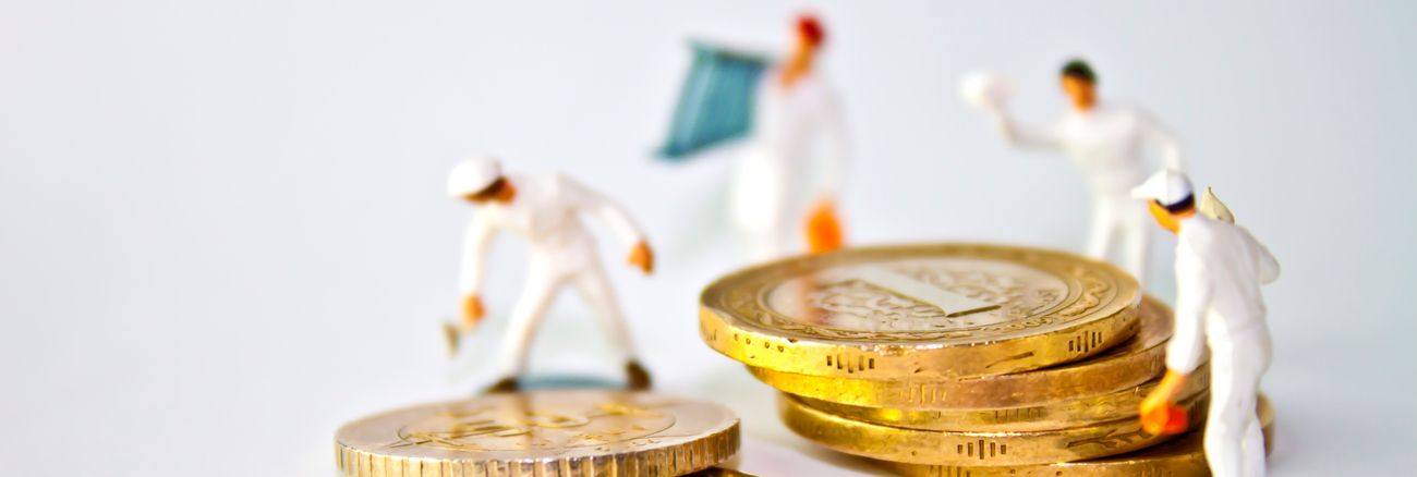 Arbeiter-Miniatur-Figuren stehen um Euro-Münzen herum © iStock/hkenanc