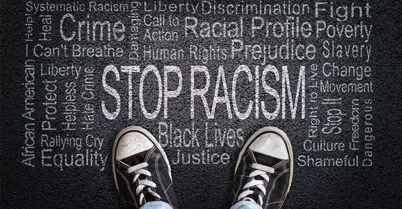 Rassismus stoppen: Eine Person sieht auf eine Wortwolke auf der Straße 