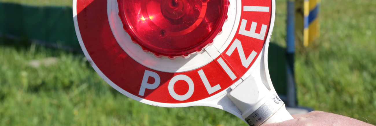 Ein Polizist hält eine Kelle mit der Aufschrift: Halt Polizei © iStock/DinaSigtrix Ein Polizist hält eine Kelle mit der Aufschrift: Halt Polizei © iStock/DinaSigtrix