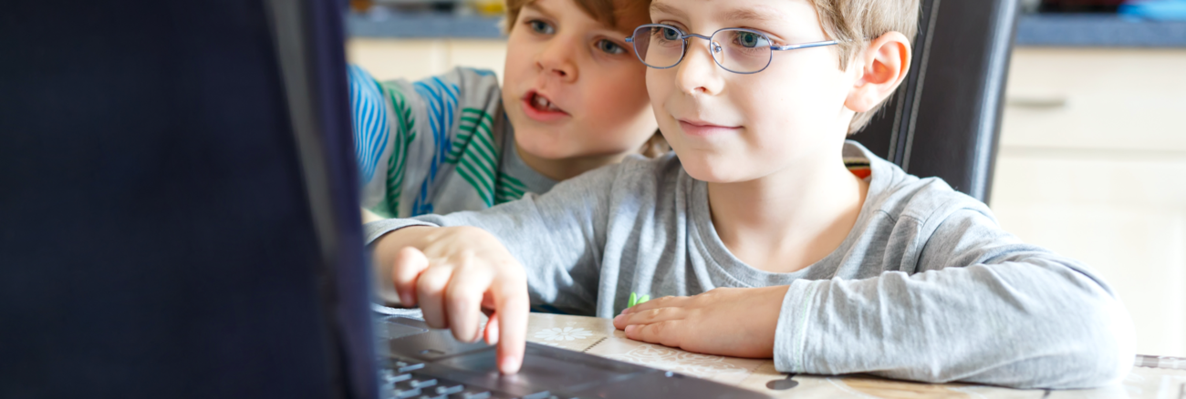 Zwei Kinder sitzen in einer Küche vor einem Computer © iStock/romrodinka