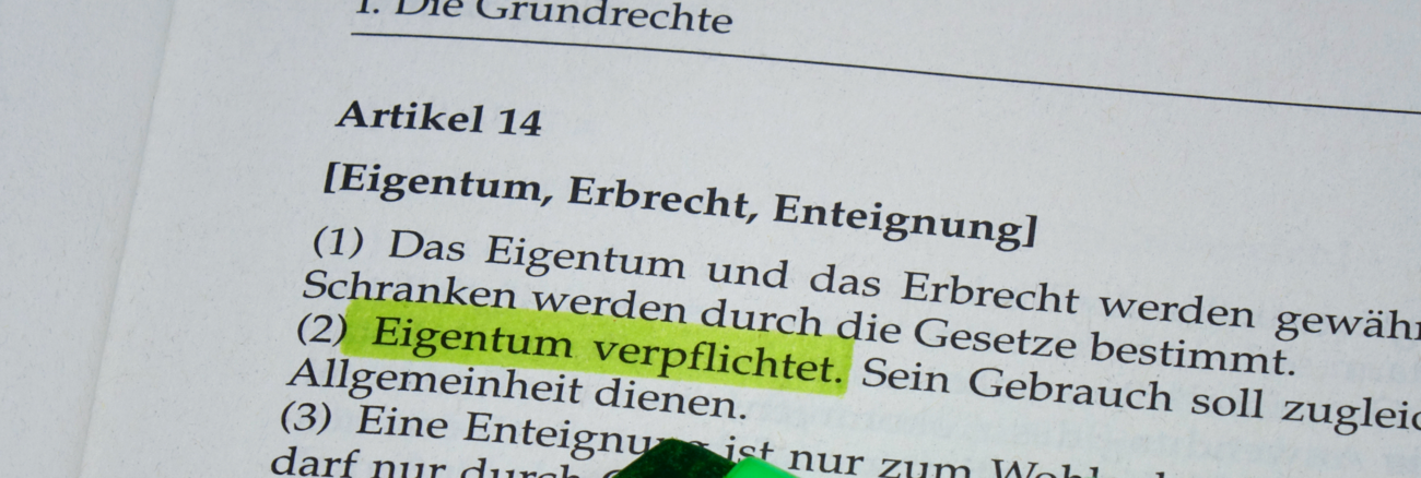 Im Artikel 14, Grundgesetz ist der Satz grün markiert: Eigentum verpflichtet. © picture alliance/ZB/Sascha Steinach