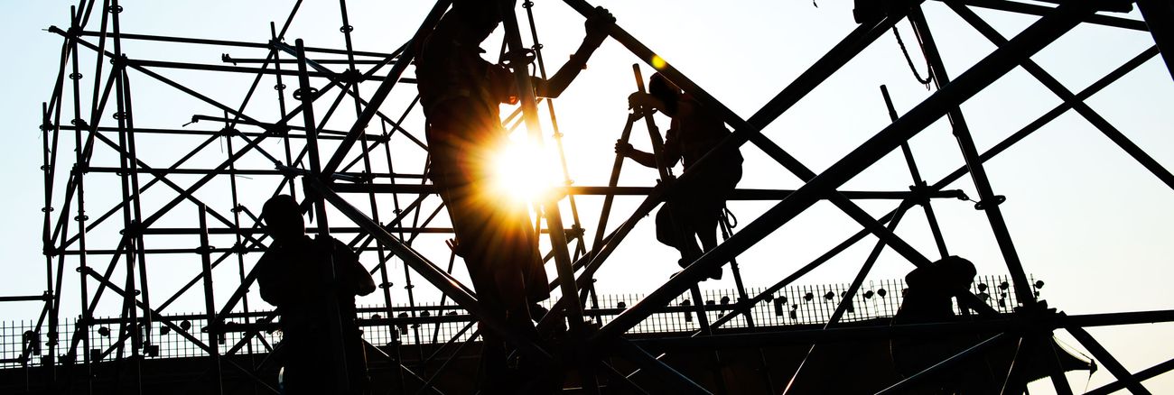 Silhouetten von Bauarbeitern, die auf einer Baustelle Gerüste montieren © iStockphoto.com/hxdbzxy Silhouetten von Bauarbeitern, die auf einer Baustelle Gerüste montieren © iStockphoto.com/hxdbzxy