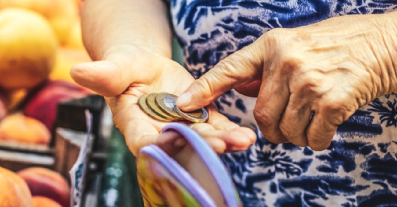Inflation, Preissteigerungen: Eine ältere Frau im Supermarkt zählt Euro-Münzen in ihrem Portemonnaie © iStock/Eva-Katalin
