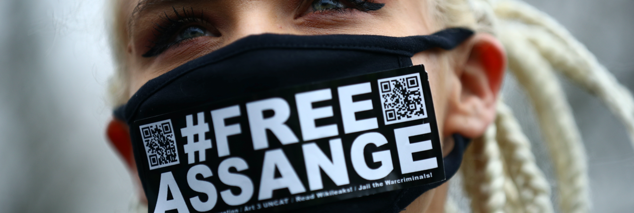 Eine Frau trägt einen schwarzen Mundschutz mit der Aufschrift #FreeAssange © REUTERS/Hannah Mckay