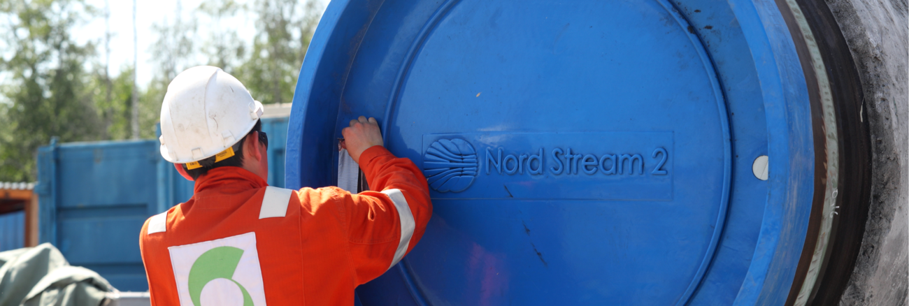 Ein Arbeiter vor einem Rohr mit blauem Verschluss und der Aufschrift Nord Stream 2 © Alexander Demianchuk/TASS/ddp/Sipa USA
