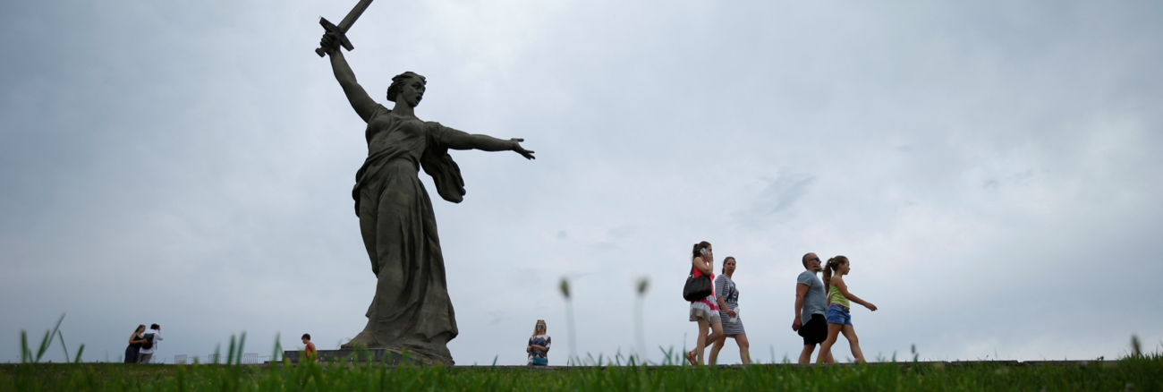 Menschen auf grüner Wiese vor der Mutter-Heimat-Statue in Wolgograd © REUTERS/David Mdzinarishvili