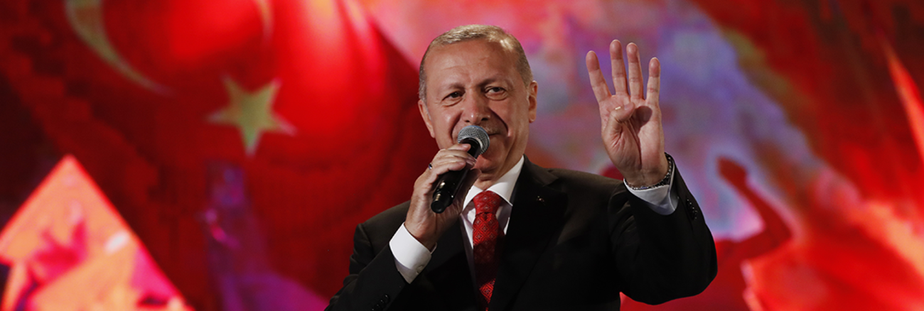 Recep Tayyip Erdogan zeigt bei einer Rede in Istanbul zum Jahrestag des gescheiterten Militärputsches am 15. Juli 2019 den Rabia-Gruß der Muslim-Brüder. Foto: © picture alliance / AP Images