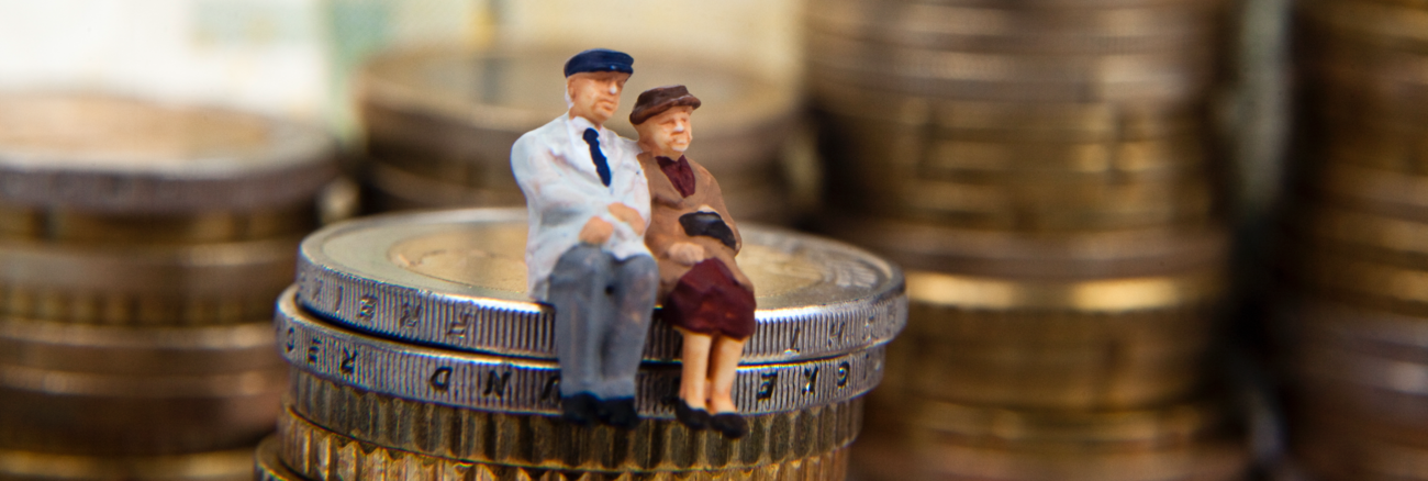 Ein Rentnerehepaar als Miniaturfiguren auf einem Haufen Euro-Münzen © iStock/macgyverhh