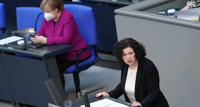 Amira Mohamed Ali am Rednerpult des Bundestages, dahinter Bundeskanzlerin Merkel auf der Regierungsbank schaut auf ihr Handy © picture alliance/Flashpic/Jens Krick