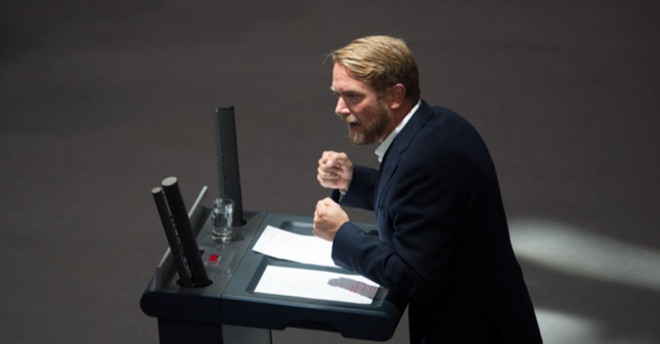 Jan Korte mit geballten Fäusten am Rednerpult des Bundestages © picture alliance/dpa/Annegret Hilse