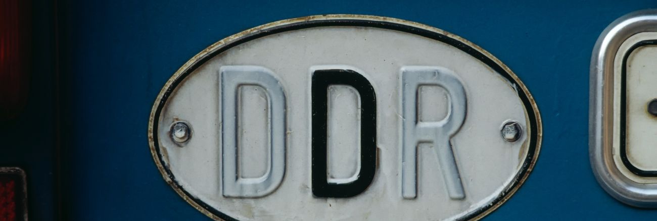 Altes DDR-Kfz-Länderkennzeichen mit dem ersten D und dem R weiß überstrichen @ iStock/clu
