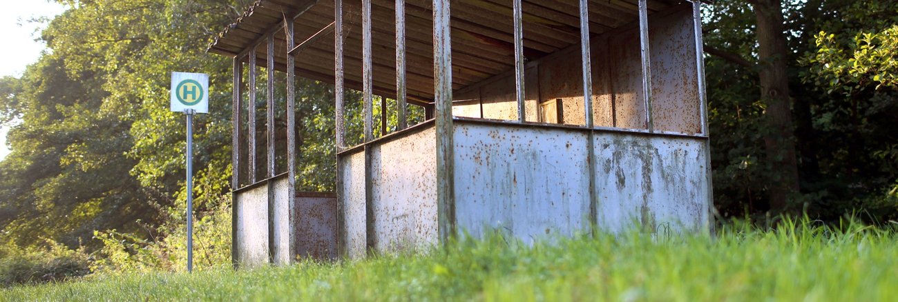 Eine verfallenes Wartehäuschen neben einem Bushalteschild in einem Dorf in Mecklenburg-Vorpommern © dpa/Jens Büttner