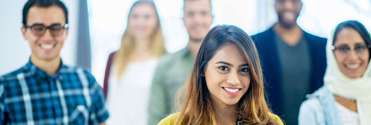 Menschen verschiedener Herkunft stehen lachend in einer losen Gruppe beieinander. | Foto: © istock.com/FatCamera