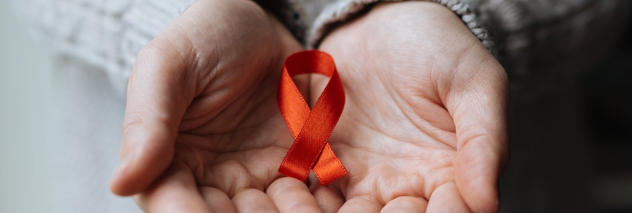 Red Ribbon, rote Schleife, das weltweite Symbol der Solidarität mit HIV-Infizierten und AIDS-Kranken © iStock/burakkarademir