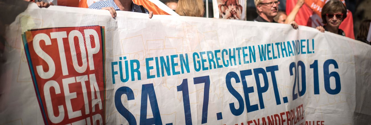 Teilnehmer einer Compact-Aktion werben mit ihrem Transparent für die bundesweiten Großdemos gegen TTIP und CETA am 17. September 2016 © Chris Grodotzki/Campact