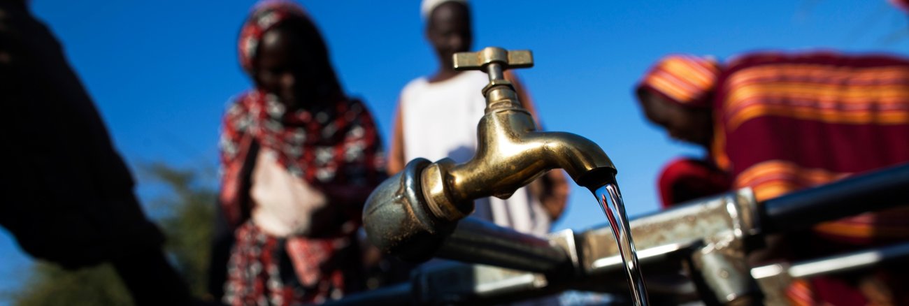 Wasser fließt aus aus einem Wasserhahn an einer öffentlichen Wasserstelle in Nord Darfur © UN Photo/Albert González Farran