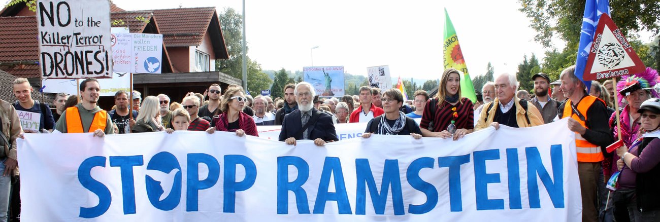 Protestierende halten ein Transparent mit der Aufschrift »Stopp Ramstein« flickr.com/Lucas Wirl