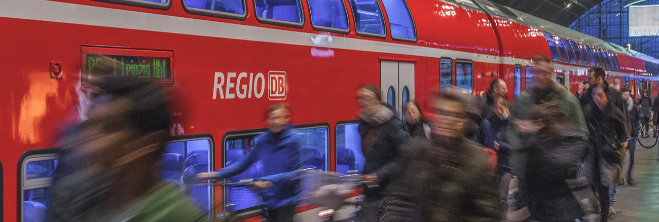  Menschen vor einem Regionalexpress der Deutschen Bahn in einem Bahnhof © iStock/kmn-network