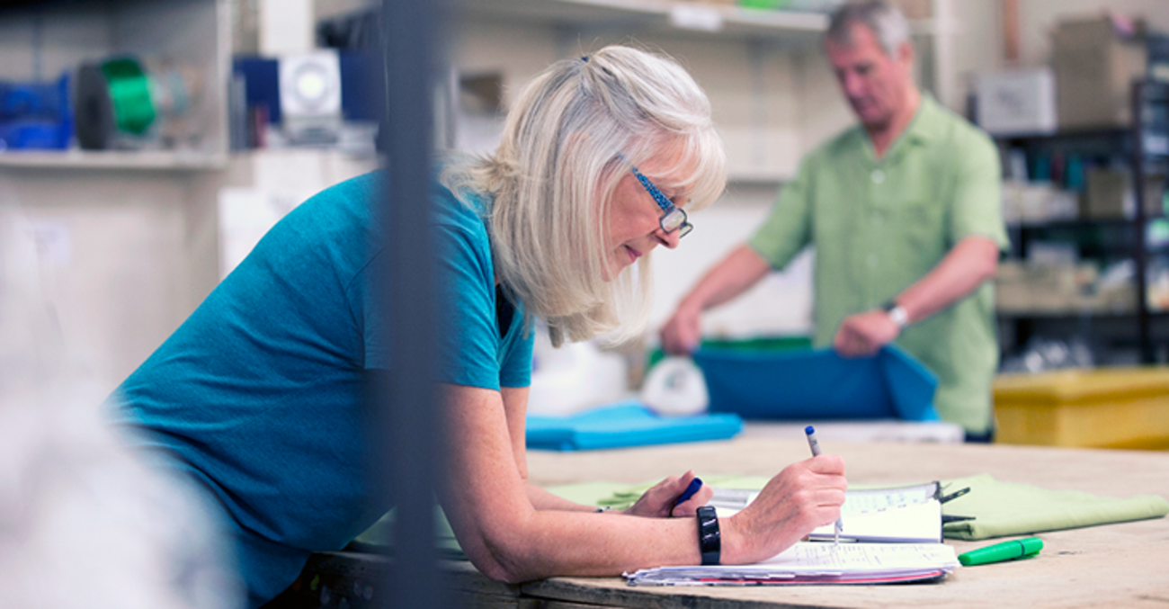 Eine Frau beugt sich über Papiere ©iStock/DGLimages 