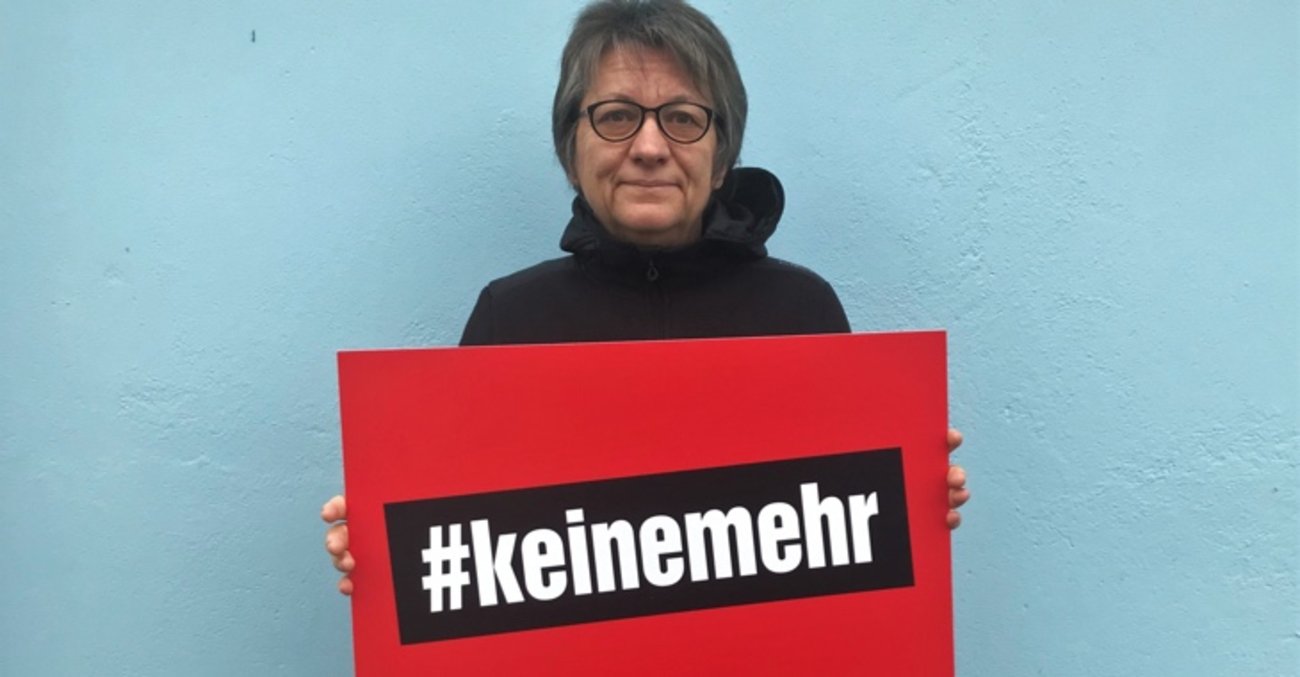 Cornelia Möhring hält zum Tag gegen Gewalt an Frauen ein Schild mit der Aufschrift #keinemehr.