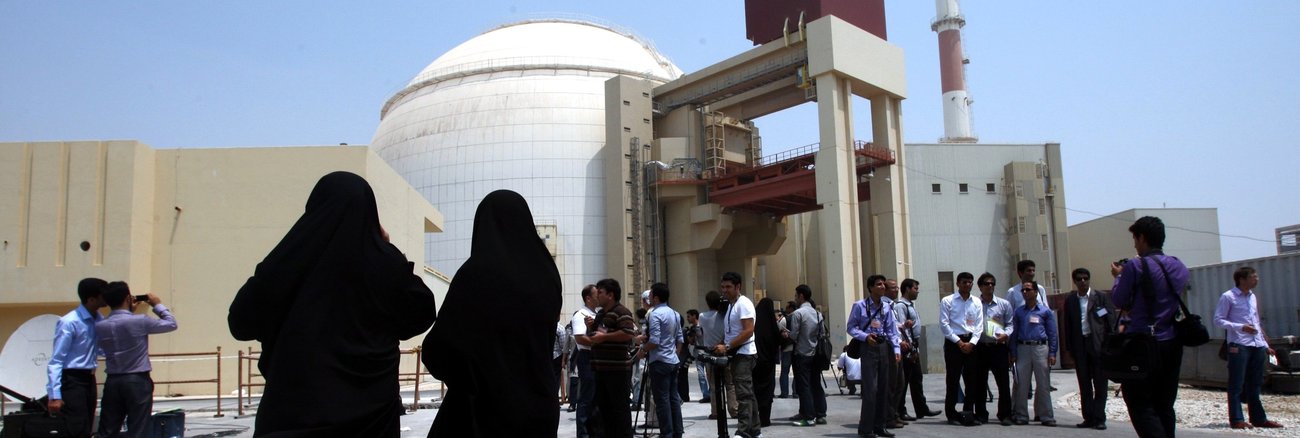 Menschen vor dem Kernkraftwerk Buschehr im Iran © dpa