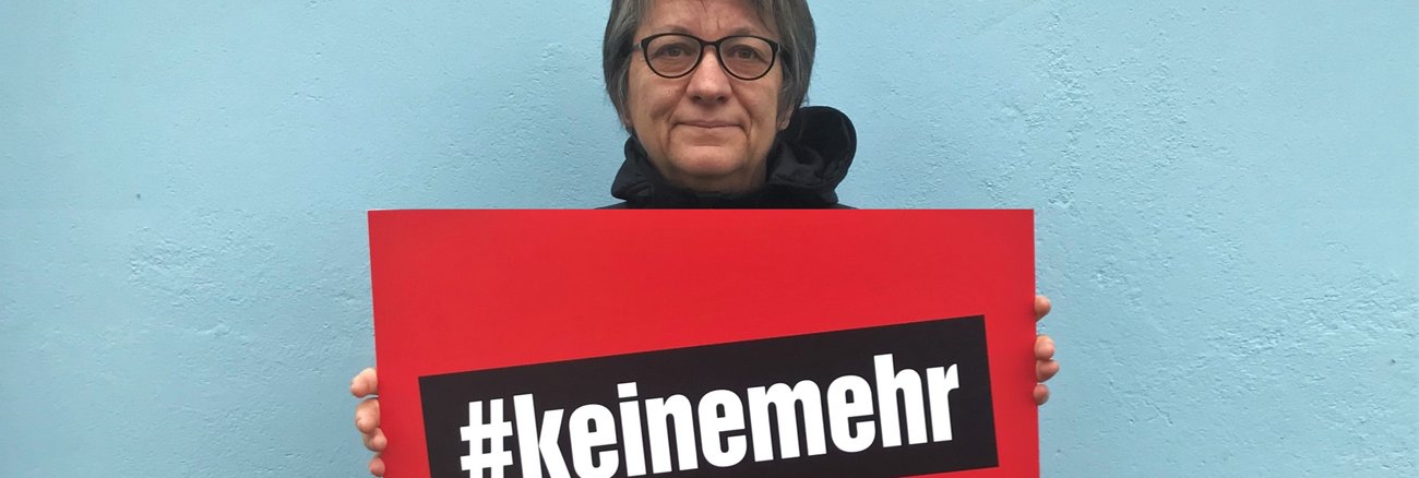 Cornelia Möhring hält zum Tag gegen Gewalt an Frauen ein Schild mit der Aufschrift #keinemehr.