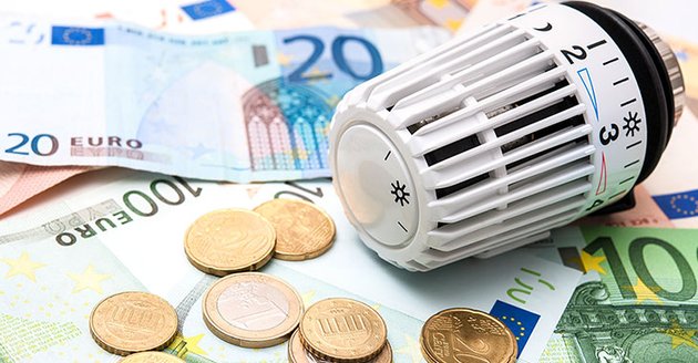 Steigende Energiekosten: Heizungsthermostat neben Euroscheinen und Münzen