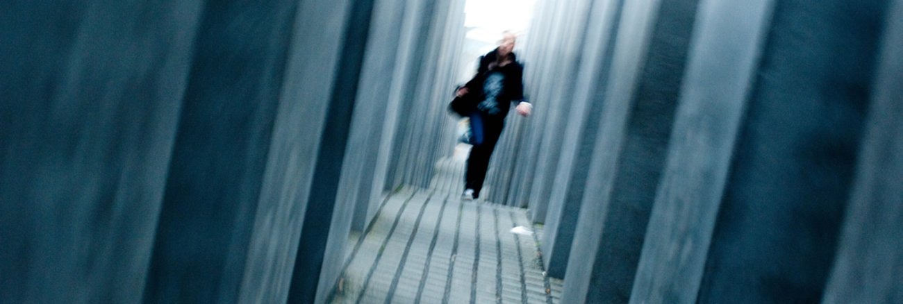 Eine Frau läuft durch das Holocaust-Mahnmal in Berlin © Raw Herring