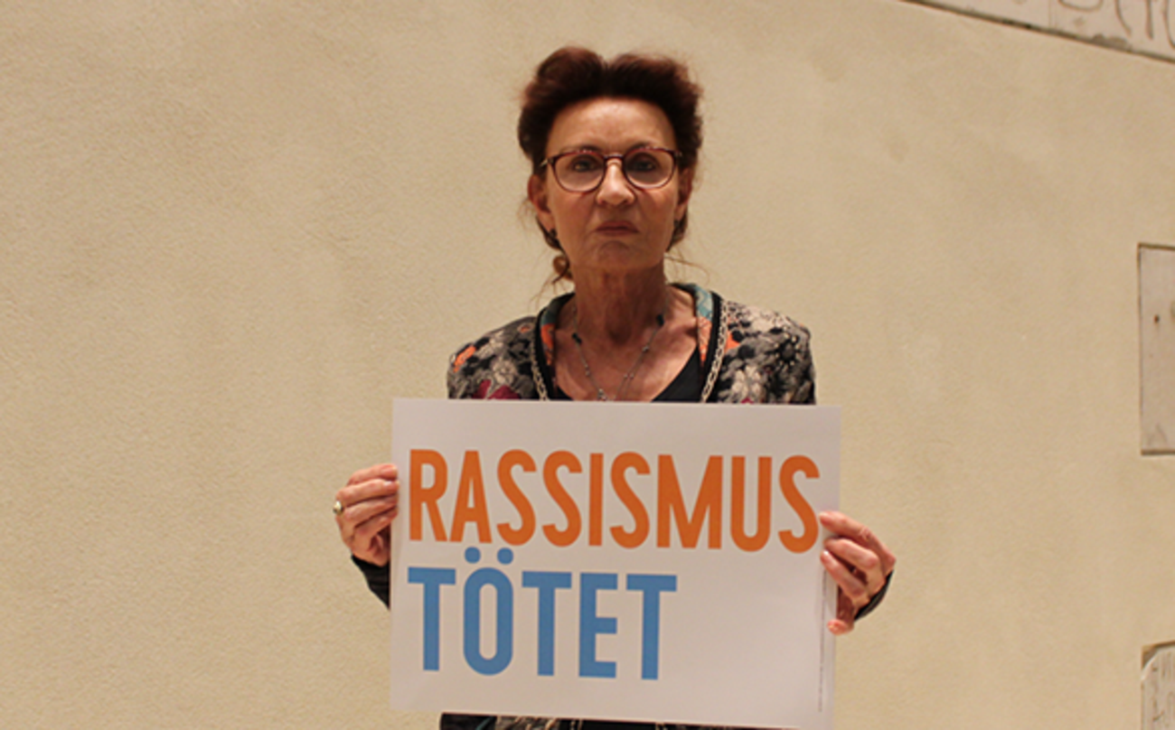 Ulla Jelpke hält ein Schild hoch: Rassismus tötet Ulla Jelpke hält ein Schild hoch: Rassismus tötet