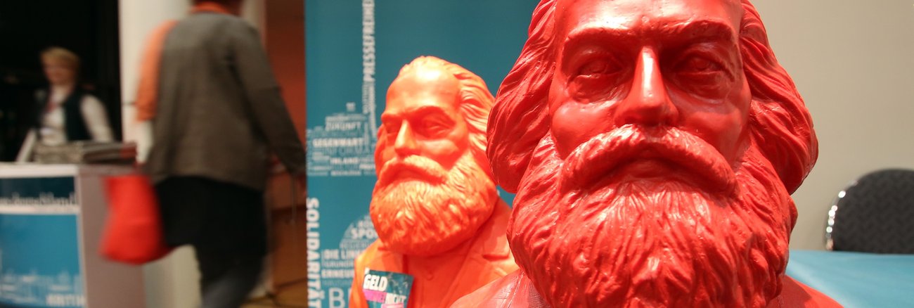 An einer roten Marx-Figur haftet ein Aufkleber mit der Aufschrift: Reich macht arm © Bodo Marks/dpa
