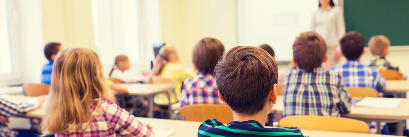 Schüler hören während einer Unterrichtsstunde einer Lehrerin zu © iStock/dolgachov