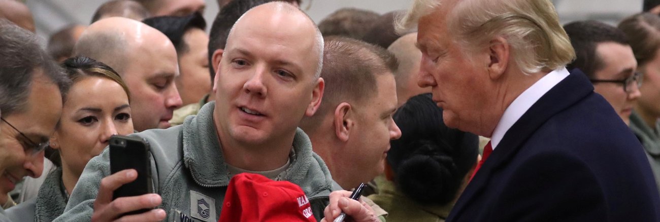 US-Präsident schreibt bei seinem Besuch der US-Air Force Base Ramstein am 27. Dezember 2018 ein Autogramm auf eine Mütze © REUTERS/Jonathan Ernst