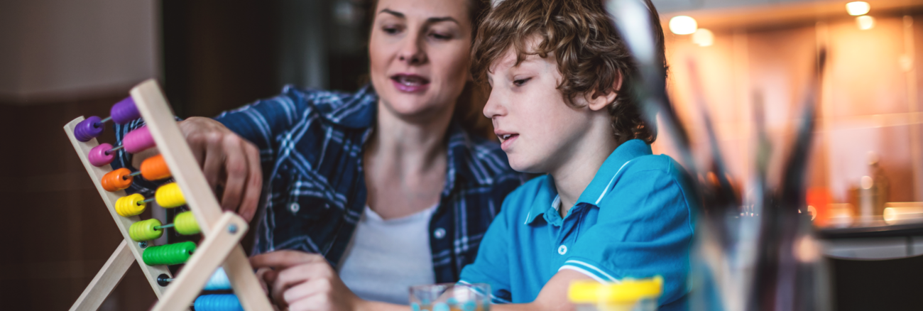 Eine Mutter mit ihrem Sohn rechnen in einem Küche an einem Abakus © iStock/MilosStankovic