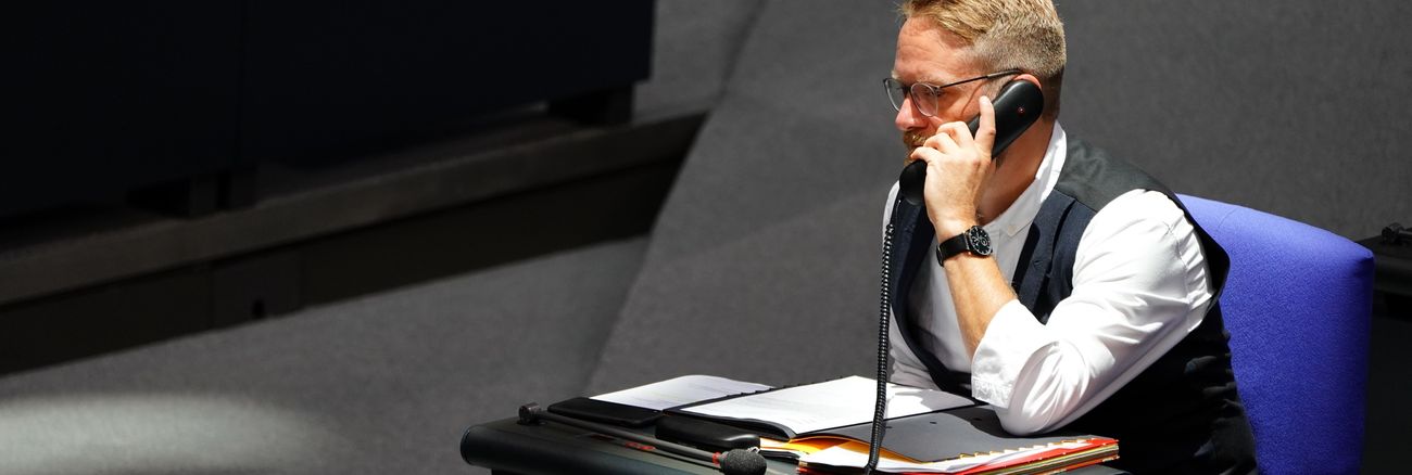 Jan Korte telefoniert an seinem Platz im Plenarsaal des Bundestages