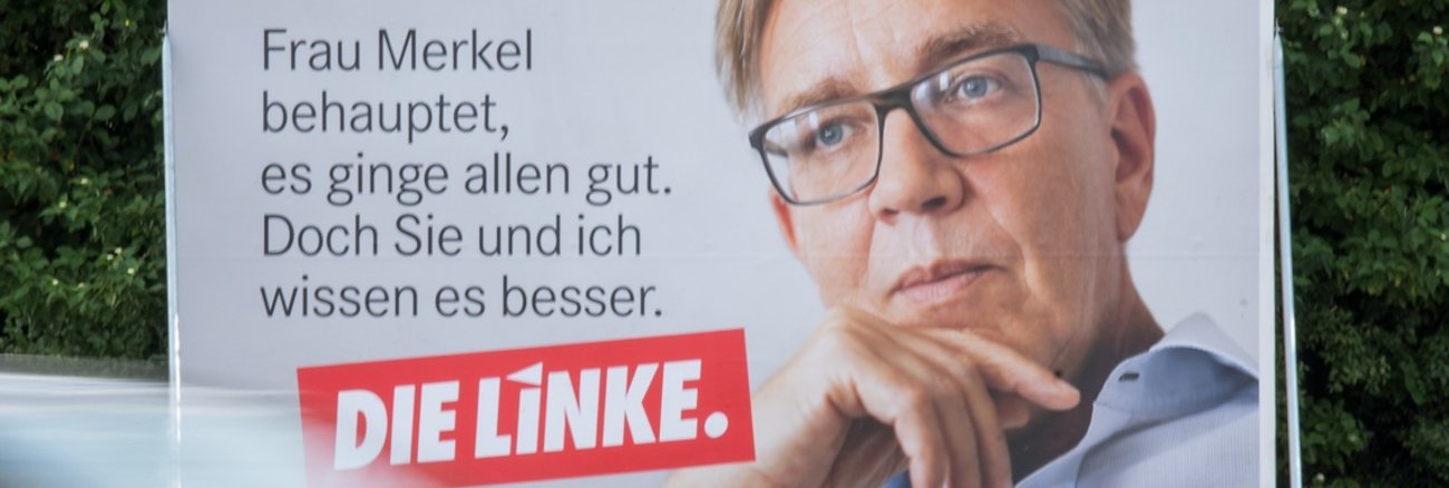 Plakat mit Zitat von Dietmar Bartsch: "Frau Merkel behauptet, es ginge allen gut. Doch Sie und ich wissen es besser." © dpa