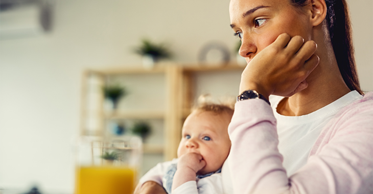 Junge Frau mit Baby besorgt guckend