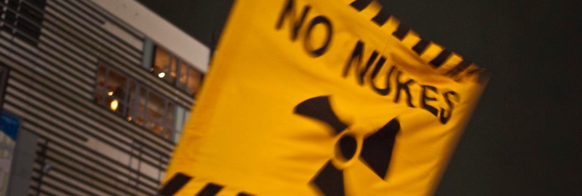 Gelbe Fahne mit der Aufschrift No Nukes und dem Atom-Symbol © flickr.com/midorisyu