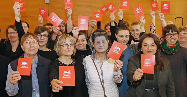 Frauen halten eine Postkarte in die Höhe: "Rote Karte gegen Sexismus"