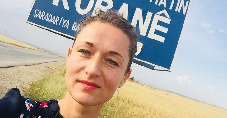 Zaklin Nastic vor dem Ortseingangsschild von Kobane Zaklin Nastic vor dem Ortseingangsschild von Kobane