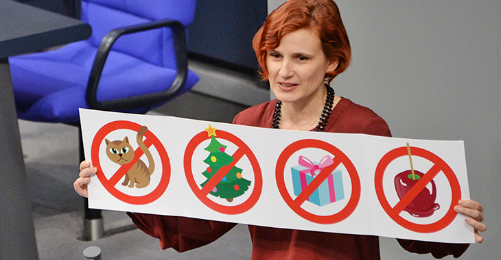 Katja Kipping hält am Rednerpult eine Grafik, die veranschaulicht, für welche Ausgaben zu Weihnachten kein Geld im Hartz-IV-Regelsatz vorgesehen ist. Foto: © Deutscher Bundestag/Achim Melde