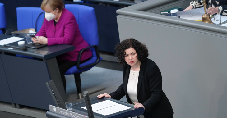 Amira Mohamed Ali am Rednerpult des Bundestages, dahinter Bundeskanzlerin Merkel auf der Regierungsbank schaut auf ihr Handy © picture alliance/Flashpic/Jens Krick Amira Mohamed Ali am Rednerpult des Bundestages, dahinter Bundeskanzlerin Merkel auf der Regierungsbank schaut auf ihr Handy © picture alliance/Flashpic/Jens Krick