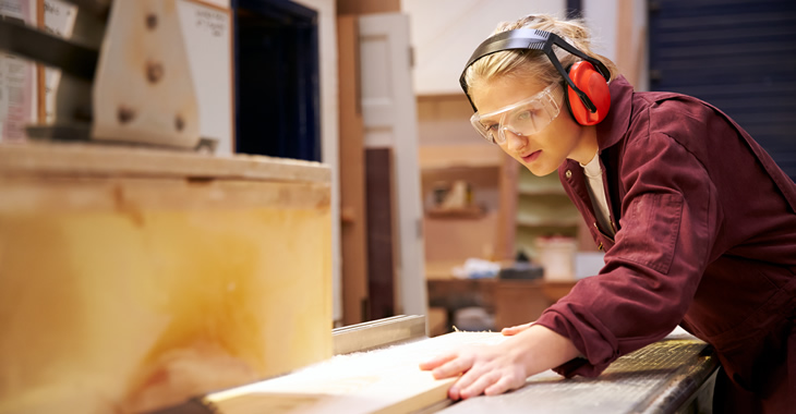 Junge Arbeiterin sägt Holzleisten an einer Kreissäge © iStockphoto.com/monkeybusinessimages