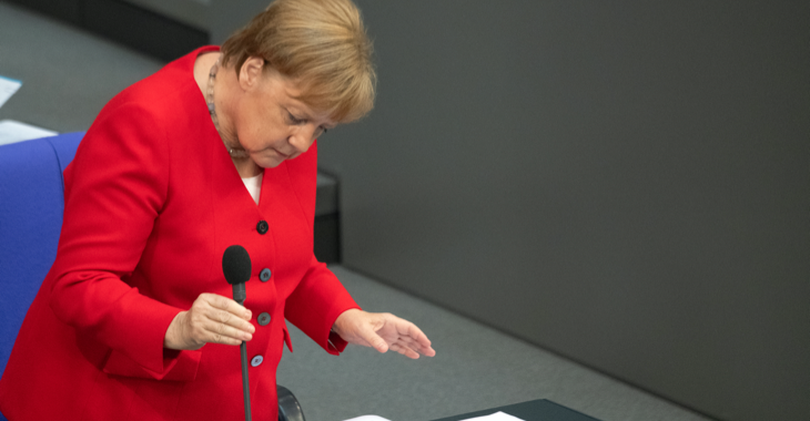 Bundeskanzlerin Angela Merkel hält ein Mikrofon auf der Regierungsbank im Plenarsaal des Bundestages © Ralf Hirschberger/dpa-Zentralbild/dpa